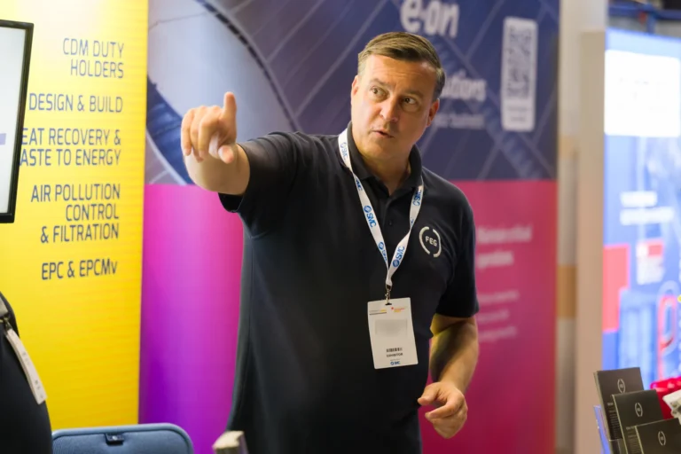 Exhibitor pointing towards a display at the 2026 Sustainable Food Factory and Food+Beverage Engineering event.